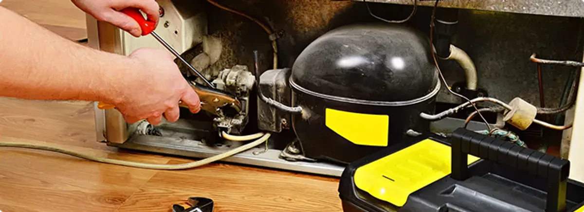 Refrigerator repair technician fixing the compressor and wiring in Fountain Hills, AZ