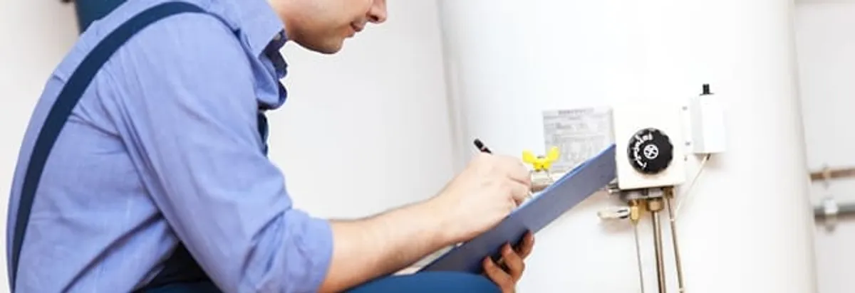 Water heater repair technician inspecting the unit and recording service notes in Mesa, AZ